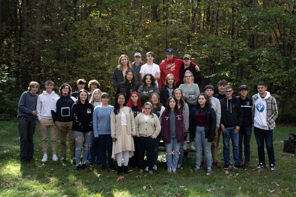Image of several students standing together for a photo near trees outdoors